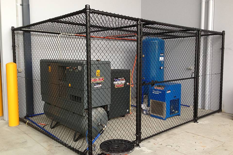 Several machines are stored in partition fence made of chain link fence.
