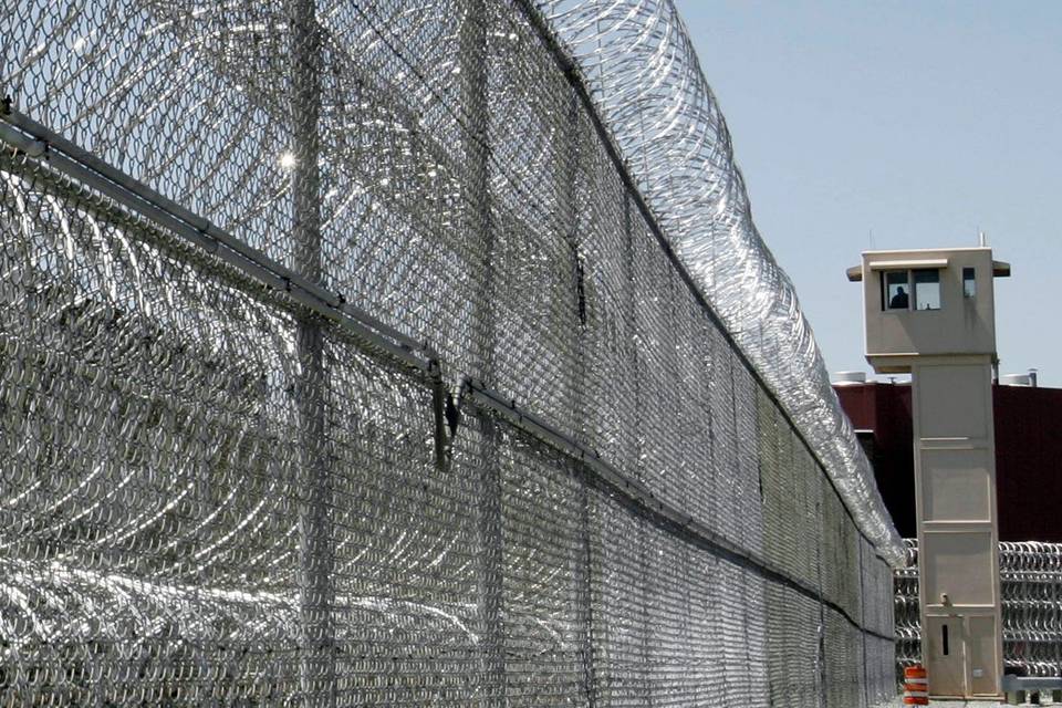 La torre de vigilancia de la prisión está rodeada por una cerca de alambre de púas.