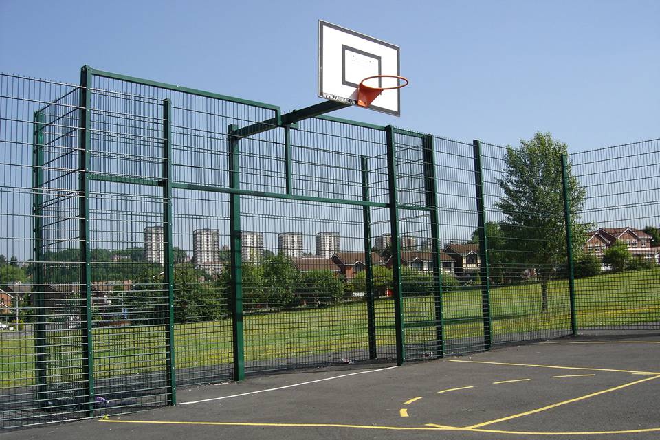 Se instalan vallas de alambre doble alrededor de una cancha de baloncesto.