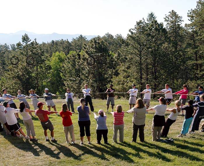 People are holding hands in a circle to do outdoor activity.