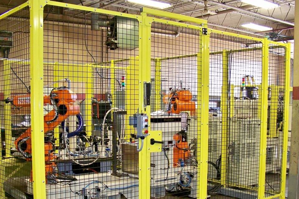 Un conjunto de máquina de procesamiento está operando en la valla de partición hecha de paneles de malla de alambre soldado.